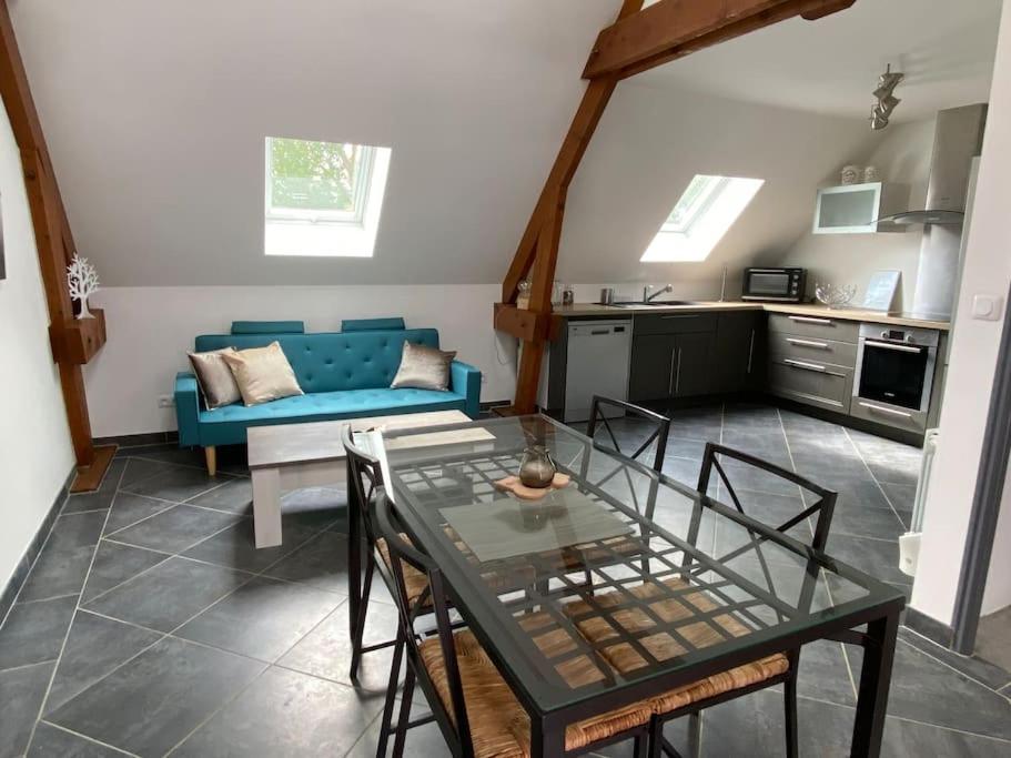 a living room with a table and a blue couch at Appart à la ferme, chez Shoopie 