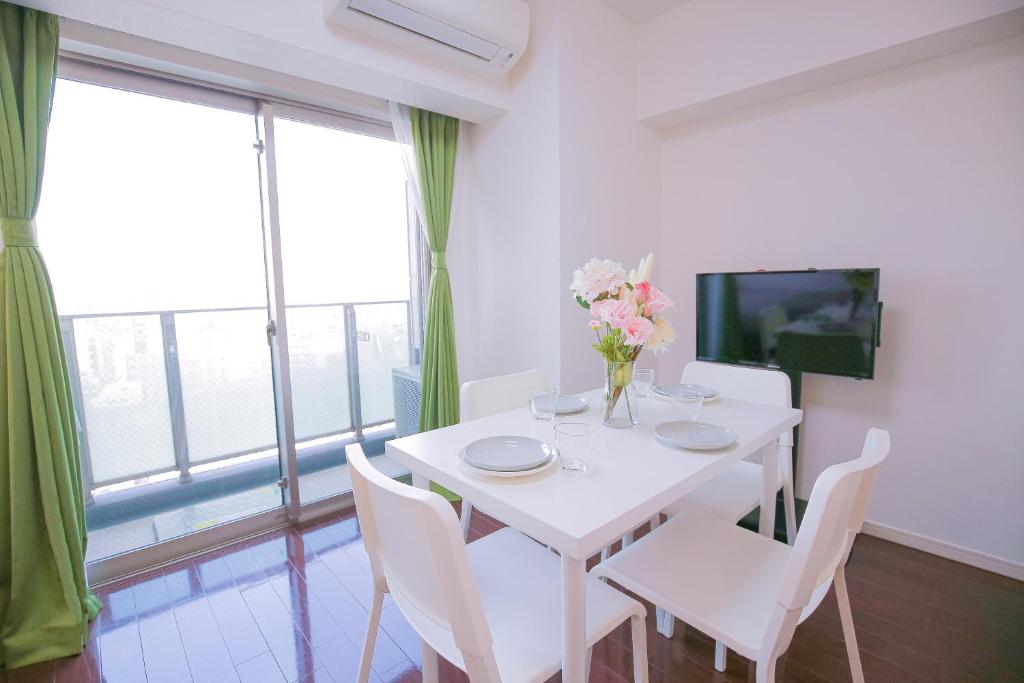 une salle à manger blanche avec une table et des chaises blanches dans l'établissement 10min walk to Shinjuku YEoE-2, à Tokyo
