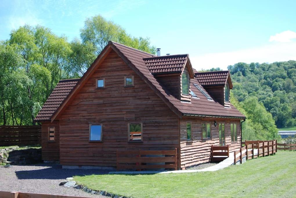 uma grande cabana de madeira com um telhado de gambrel em The Neuk Achmore Plockton em Stromeferry