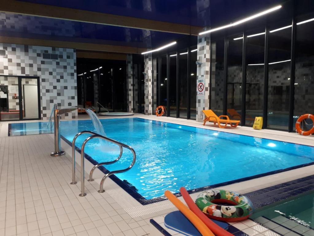 a swimming pool with a slide in a building at Apartamenty BEST HOME & SPA in Ustronie Morskie