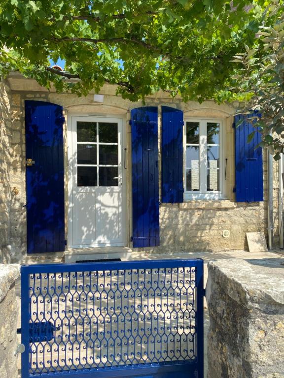 une maison bleue avec des portes bleues et une clôture dans l'établissement Maison de pays la Chefmaliere, à La Cotinière