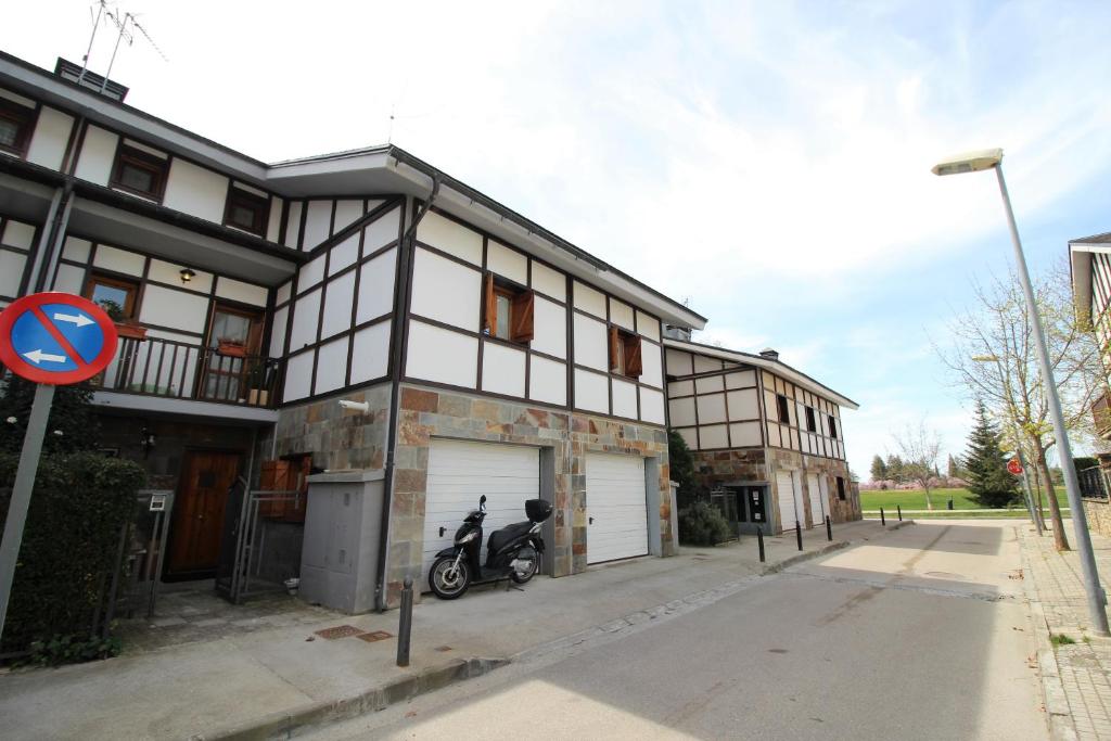 a house with a motorcycle parked in front of it at Chalet junto a la Ciudadela de Jaca in Jaca
