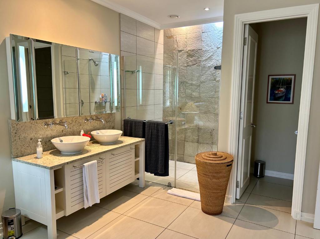 łazienka z 2 umywalkami i prysznicem w obiekcie Eden Island (GIE Apartment) w mieście Eden Island