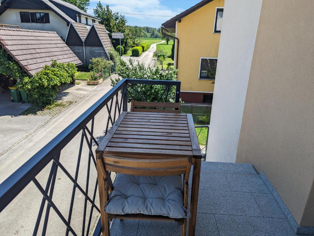 un banc en bois assis sur le balcon d'une maison dans l'établissement Domen's cozy rentals, à Kranj