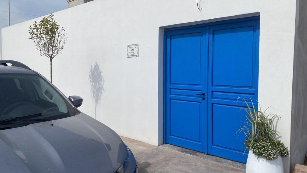 una puerta de garaje azul con un coche estacionado al lado en La Puerta Azul San Carlos en San Carlos