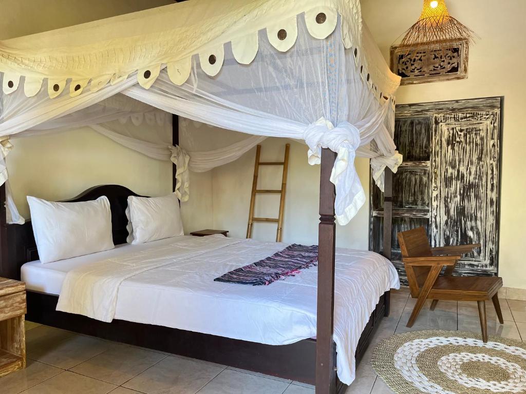 um quarto com uma cama de dossel e uma escada em Adi's Bungalow em Uluwatu