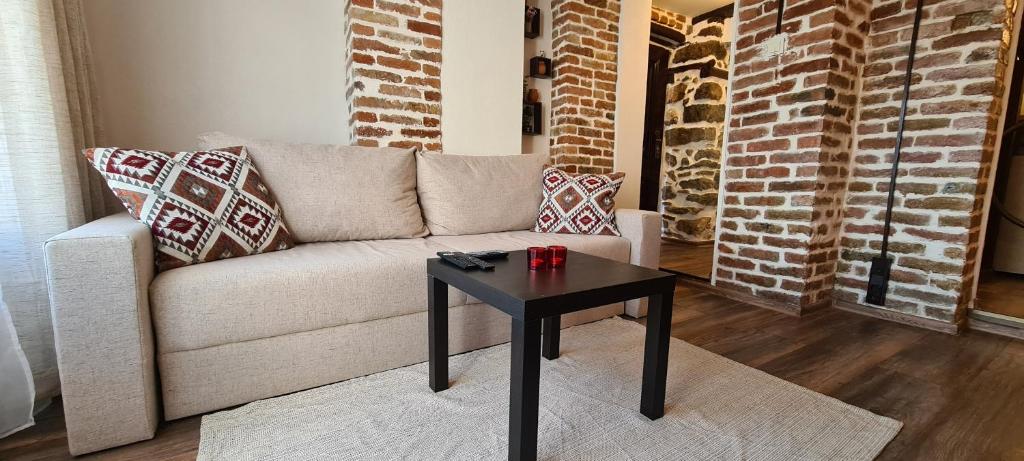 uma sala de estar com um sofá e uma mesa em Lazarov Suites - country style luxury appartements em Veliko Tarnovo