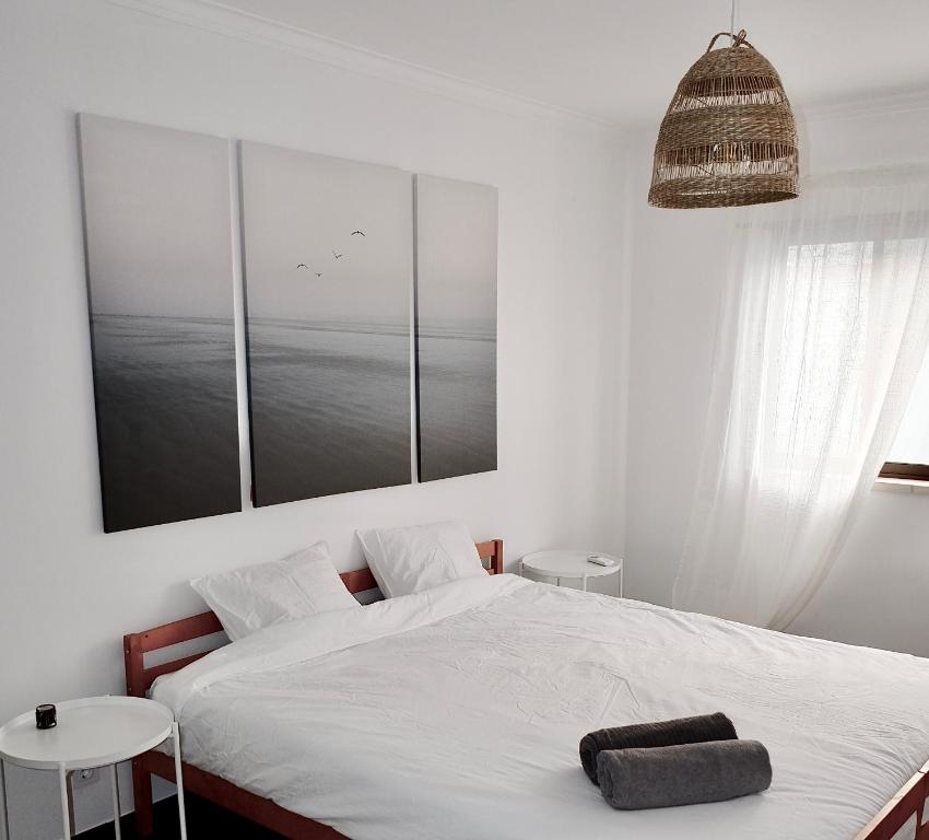 Caparica Coast Townhouse Apartments في تشارنكه: غرفة نوم عليها سرير وفوط