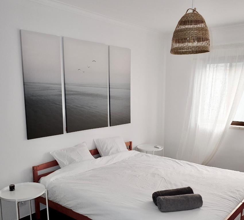 a bedroom with a bed with a towel on it at Caparica Coast Townhouse Apartments in Charneca