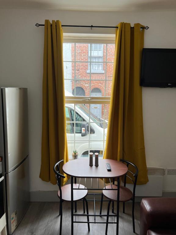 a small table and chairs in a room with a window at Ground Floor Two Bed Cairo Street in Warrington