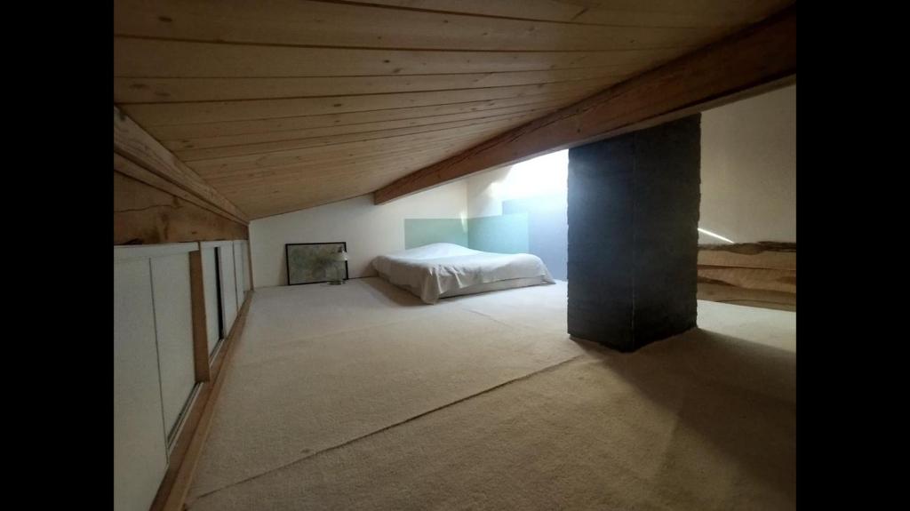 a bedroom with a bed and a wooden ceiling at Appartement 4 personnes in Briançon
