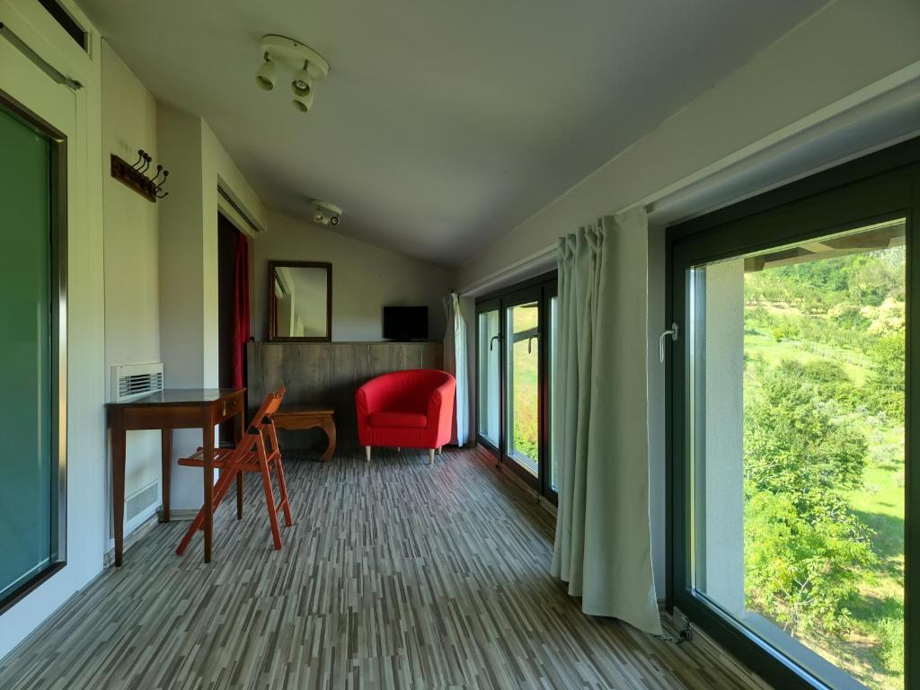 soggiorno con scrivania e sedia rossa di Camera Aminta - Casa Aminta a Valtesse