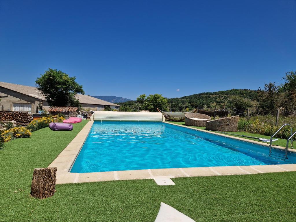a large blue swimming pool in a yard at Gîte de Navacelles in Blandas