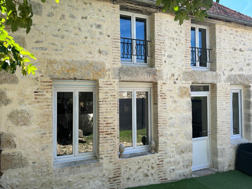 une maison en pierre avec des fenêtres latérales dans l'établissement JOLIE MAISON AVEC JARDIN PRIVE DANS LE CENTRE VILLE DE BRIARE, à Briare