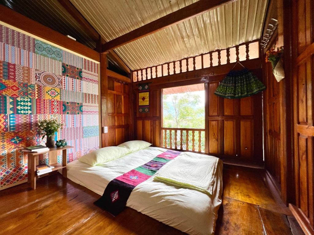 a bedroom with a bed in a room with a window at An's House in Ha Giang