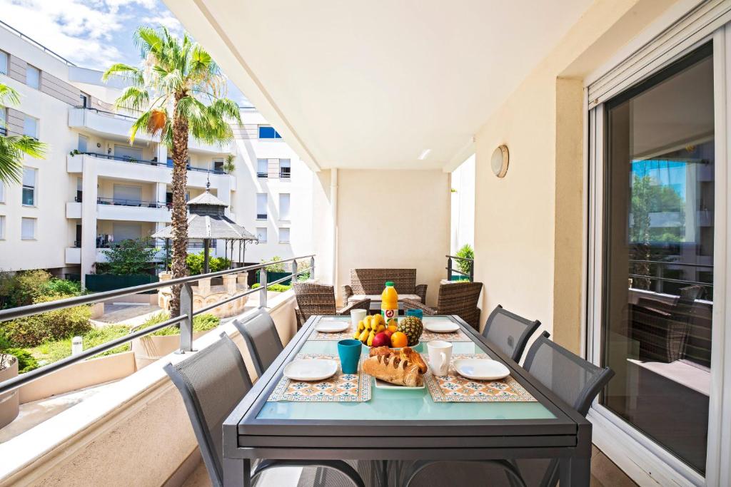 einen Tisch mit Obst auf dem Balkon in der Unterkunft Le Palmier Vert - Magnifique T2 à Montpellier- Balcon 16m2 - CLIM -WIFI in Montpellier