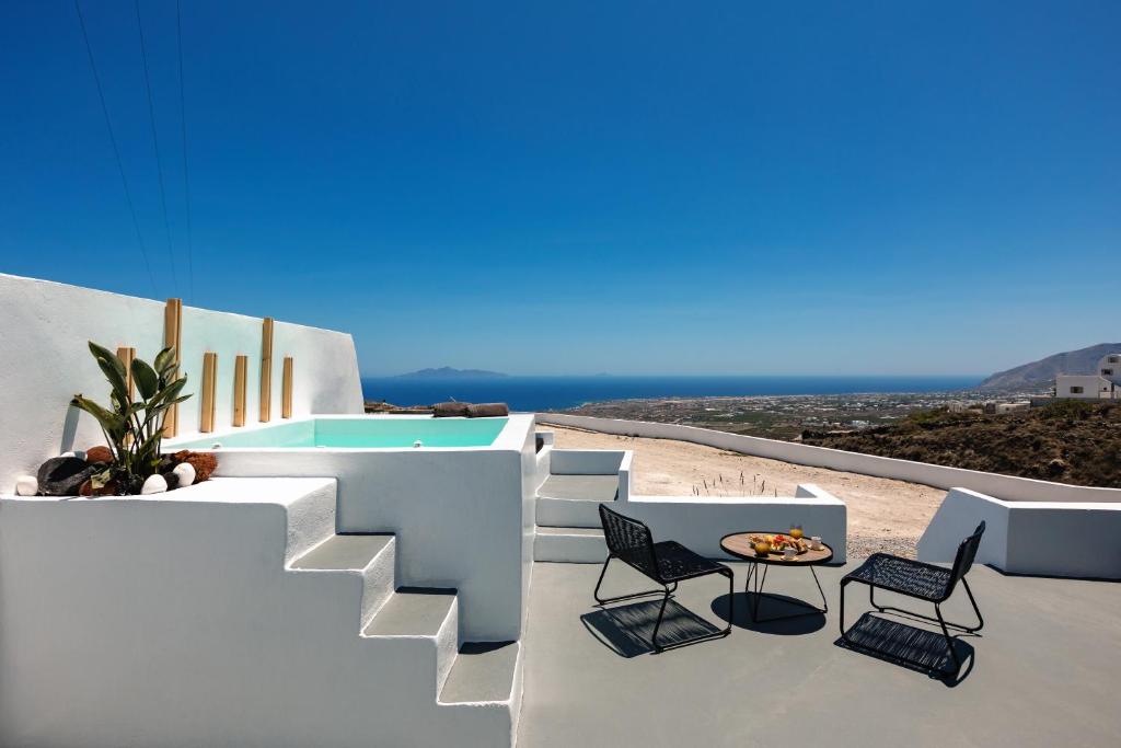 a patio with chairs and a table on a building at Lackos Luxury Suites in Imerovigli