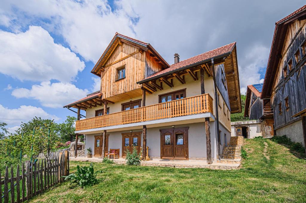 uma grande casa de madeira com uma cerca em ECO Tourist Farm Kostanje em Sevnica
