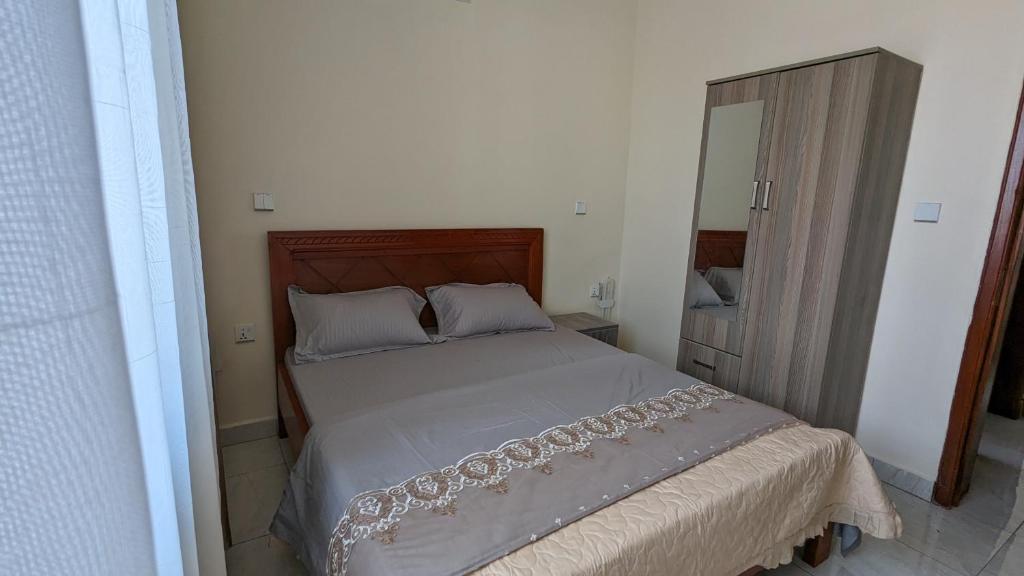 a bedroom with a large bed with a mirror at Star Max Apartments in Kigali