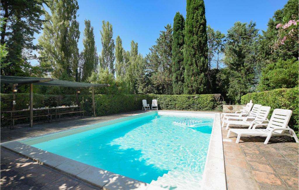 uma piscina com cadeiras brancas e árvores em Beautiful Home In Rivotorto Di Assisi With Wifi em Passaggio Di Assisi