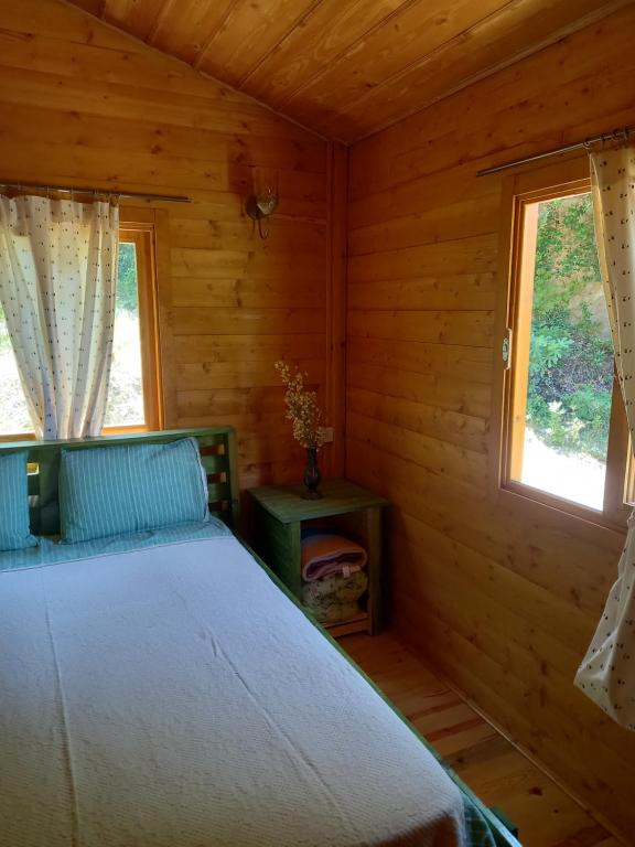 um quarto com uma cama num chalé de madeira em Şirince mağara deresi evleri. em Selçuk