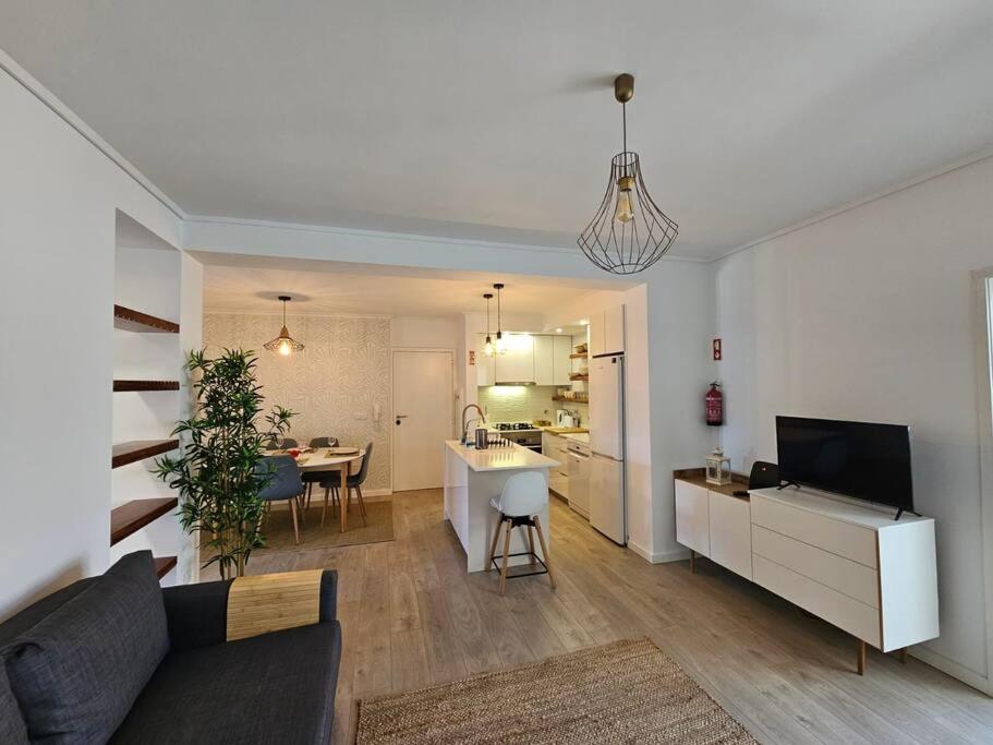 a living room and kitchen with a couch and a table at Ria Sol Mar Apartment Costa Nova in Costa Nova