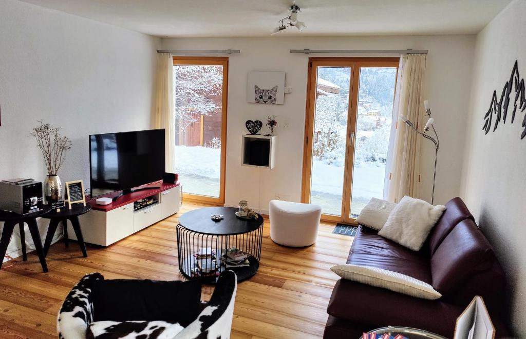 a living room with a couch and a tv at Bune in Fiesch