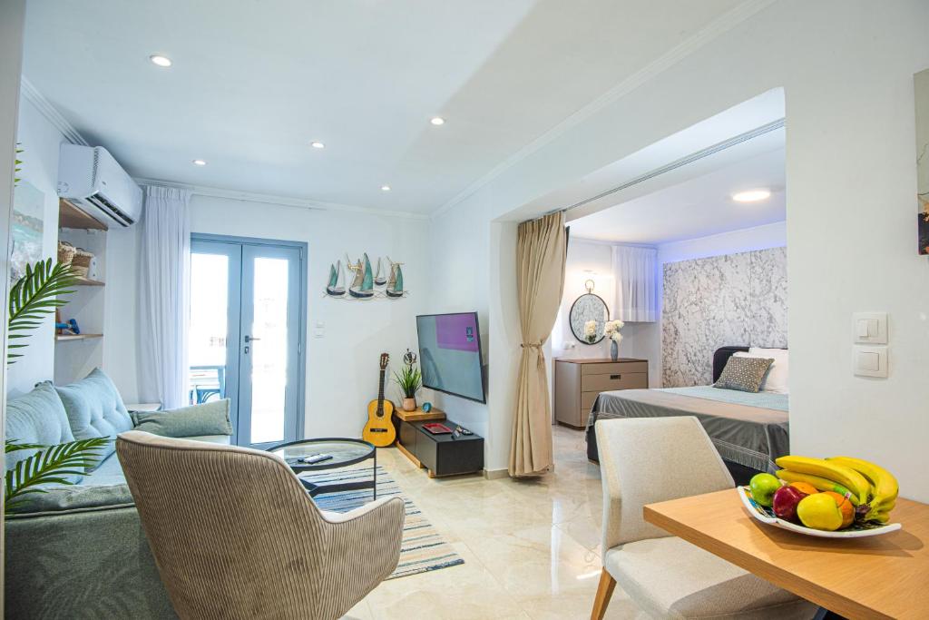 a living room with a bed and a table with a bowl of fruit at Solomon Premium House in Kritsa