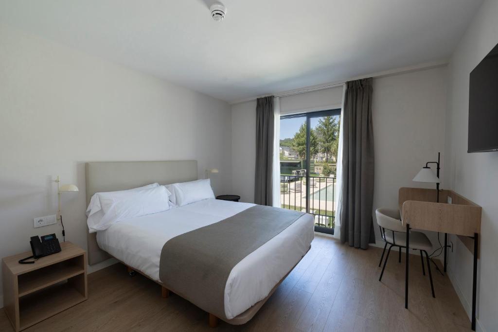 a hotel room with a bed and a balcony at Hotel H4 Cangas 3 Superior in Cangas de Morrazo