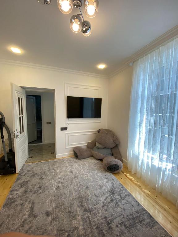 a living room with a teddy bear sitting on the floor at Dream House Oguz in Oğuz