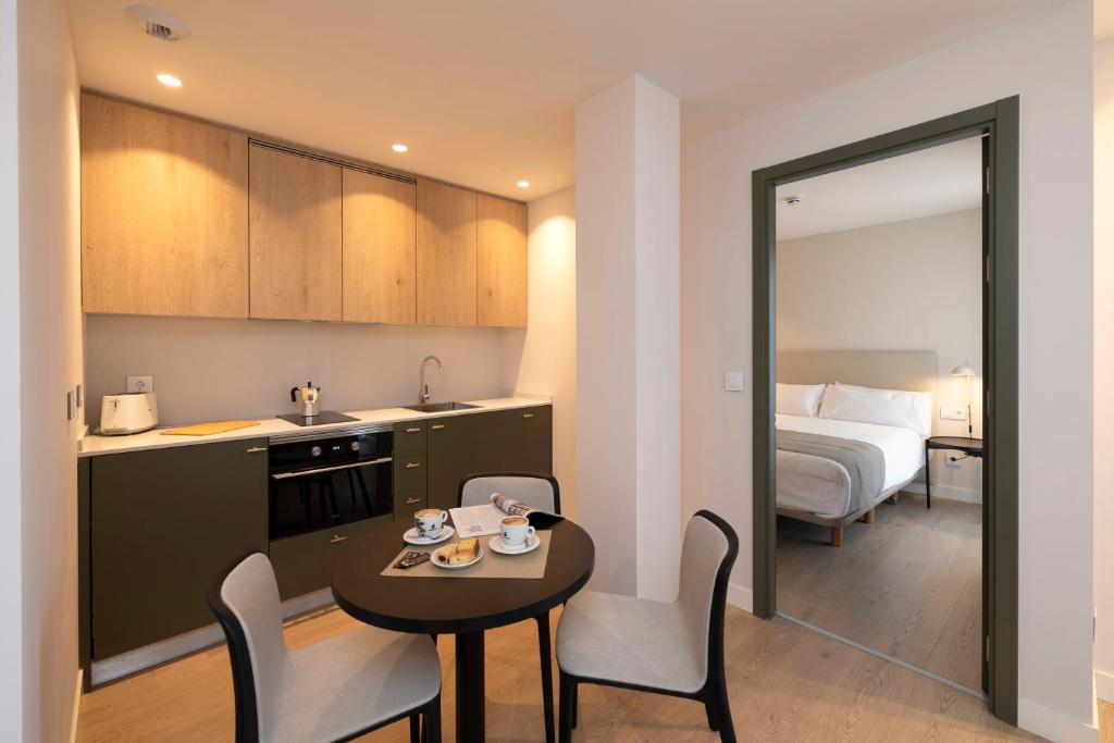 a kitchen and a room with a table and a bed at Hotel H4 Cangas 3 Superior in Cangas de Morrazo