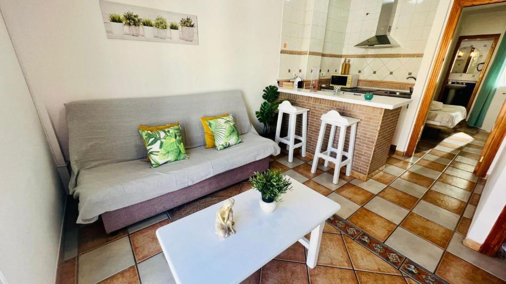 a living room with a couch and a kitchen at Apartamento Jimena Cadiz en el centro de Nerja in Nerja