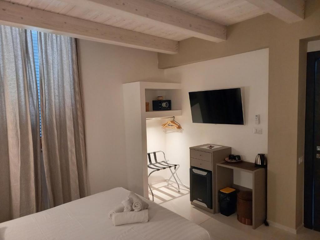 1 dormitorio con 1 cama, TV y silla en Dimora50, en Porto Recanati