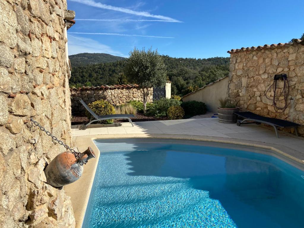 - une piscine sur le côté d'un bâtiment en pierre dans l'établissement Guest houses - Les Pierrons, à Le Revest-les-Eaux
