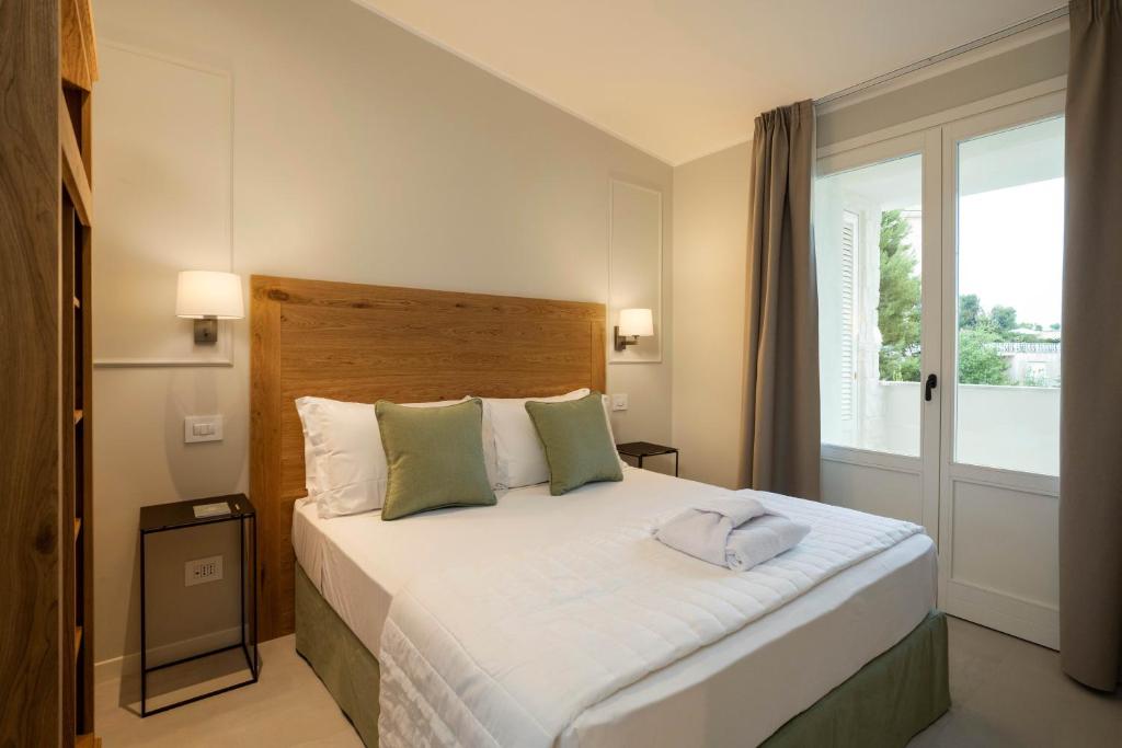 a bedroom with a large bed and a window at Borgopetra Resort in Numana