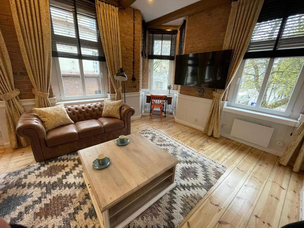 a living room with a couch and a coffee table at Apartments PSD - Filmowa in Słupsk