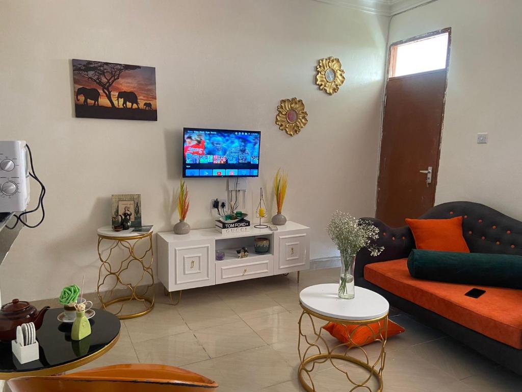 ein Wohnzimmer mit einem Sofa und einem Flachbild-TV in der Unterkunft Davkin Apartments in Mombasa