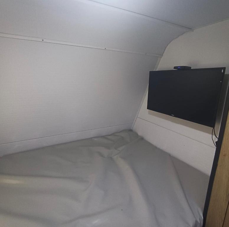 mały pokój z łóżkiem i telewizorem z płaskim ekranem w obiekcie האירוח המושלם בקטנה בקרוואן w Tel Awiwie