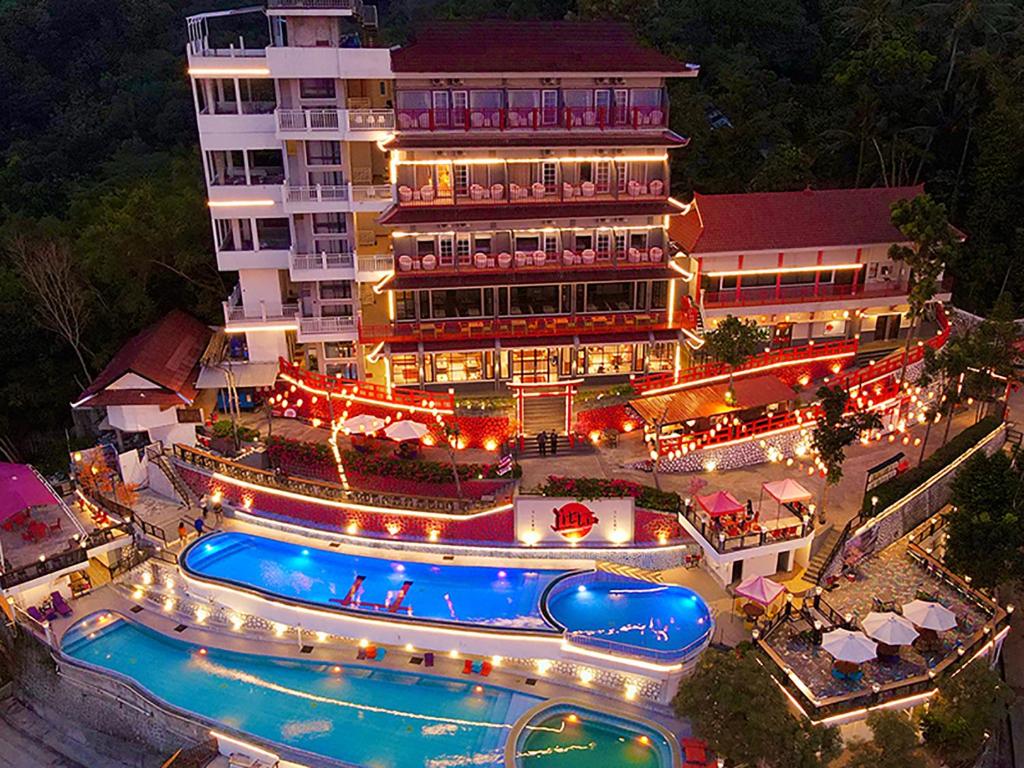 a hotel with a swimming pool in front of a building at Little Tokyo in Yogyakarta