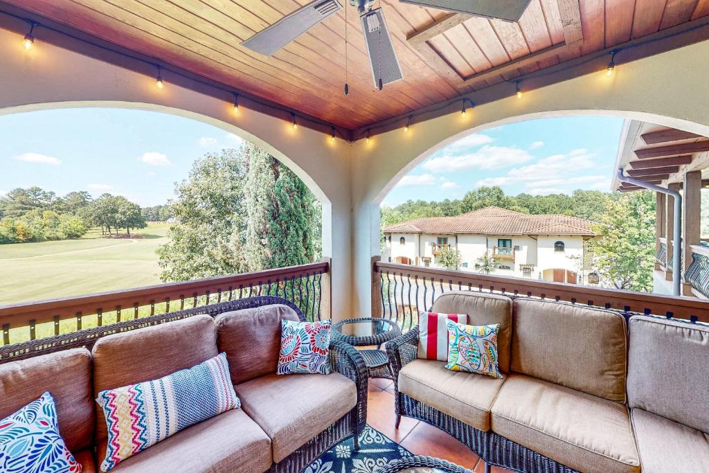 a screened in porch with two couches on a balcony at Abruzzi - Villa C in Eatonton 
