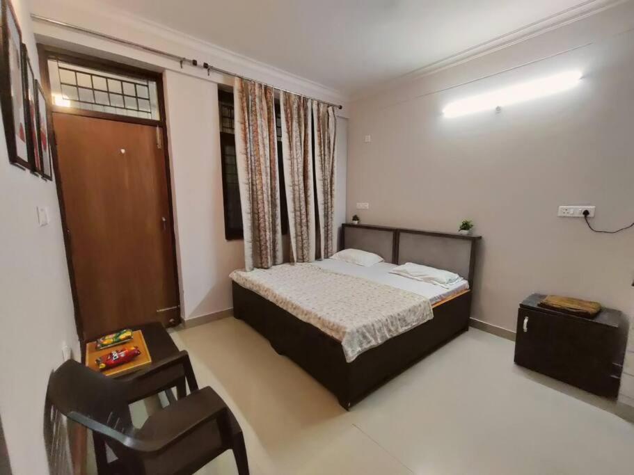 um quarto com uma cama e uma cadeira em RJ Homestay em Dehradun