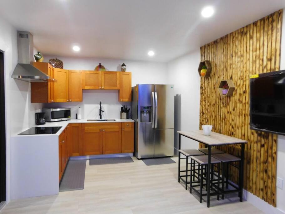 a kitchen with wooden cabinets and a stainless steel refrigerator at cozy apartment, with separate entrance in Miami