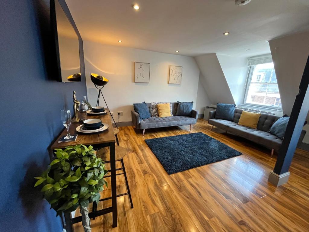 a living room with a couch and a table at Magnificent One Bed Penthouse in Nottingham