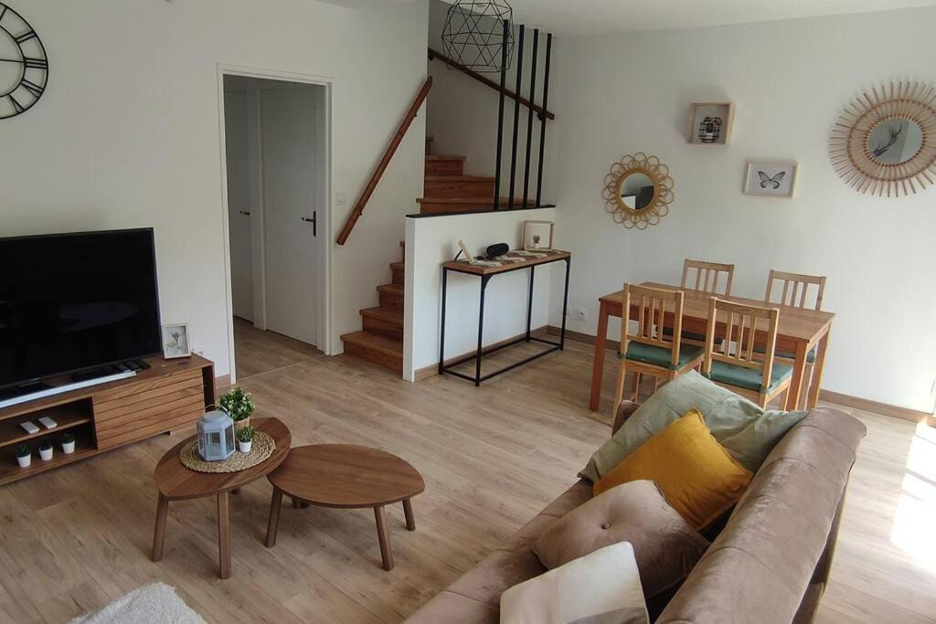 een woonkamer met een bank en een tafel bij Beau Duplex Cenon résidence calme, vue arborée in Cenon
