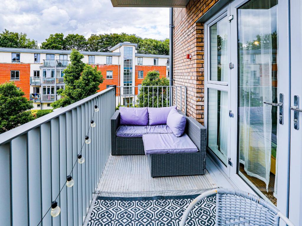 een balkon met een paarse bank op een balkon gmaxwell gmaxwell gmaxwell bij Pass the Keys Cosy Apartment in the heart of Chelmsford in Chelmsford