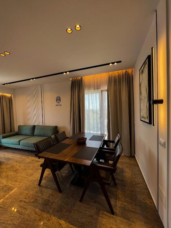 a living room with a table and a couch at Olivea Apartments in Velipojë