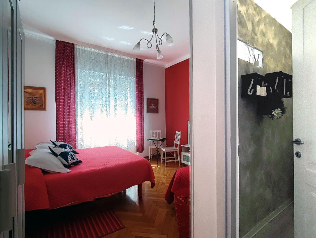 Schlafzimmer mit roten Wänden und einem Bett mit einer roten Decke in der Unterkunft Bed & Chic bed & breakfast in Triest