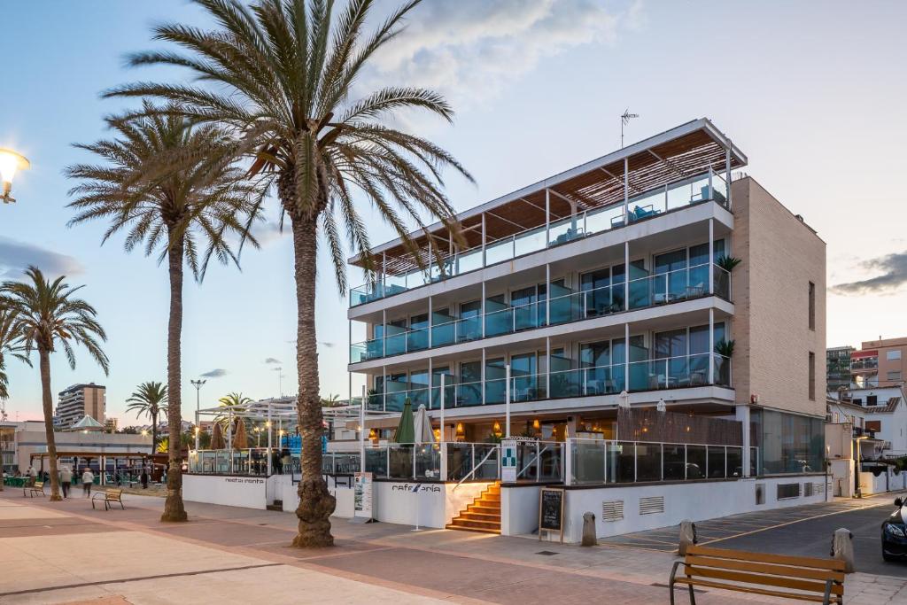 un edificio con palmeras delante en Meraki Beach Hotel - Only Adults, en Playa de Pobla de Farnals