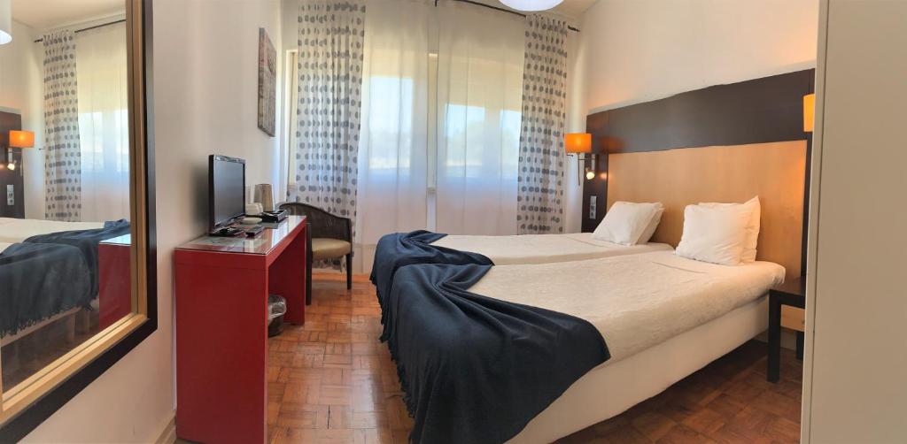 Cette chambre comprend un grand lit et un miroir. dans l'établissement Discovery Apartment Benfica, à Lisbonne