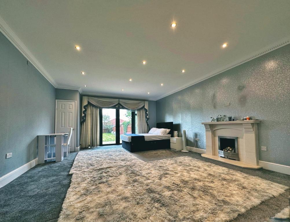 sala de estar amplia con chimenea y sofá en Blue rain en Hillingdon